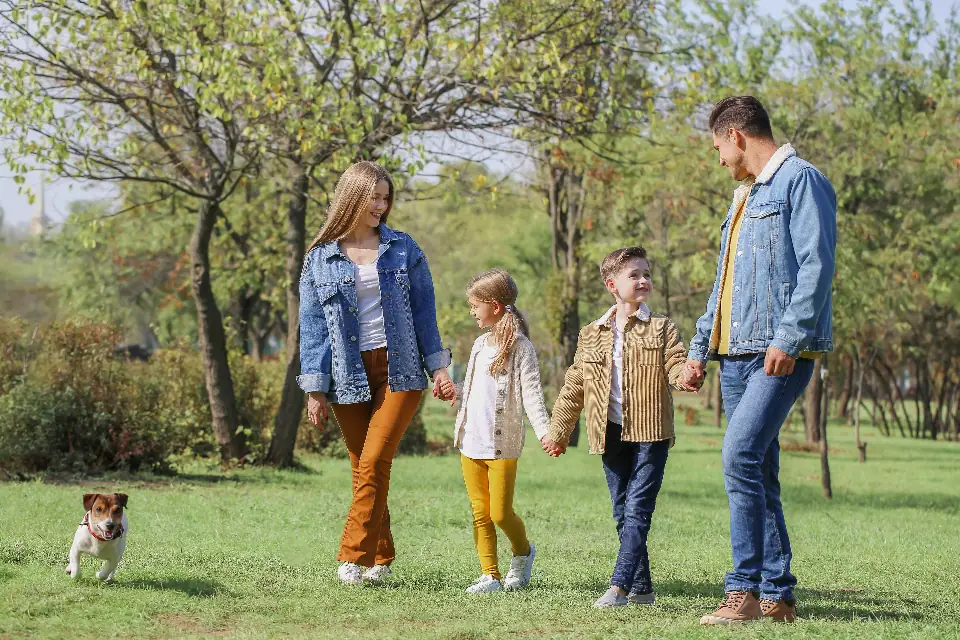 A family walking together through a park on a sunny morning